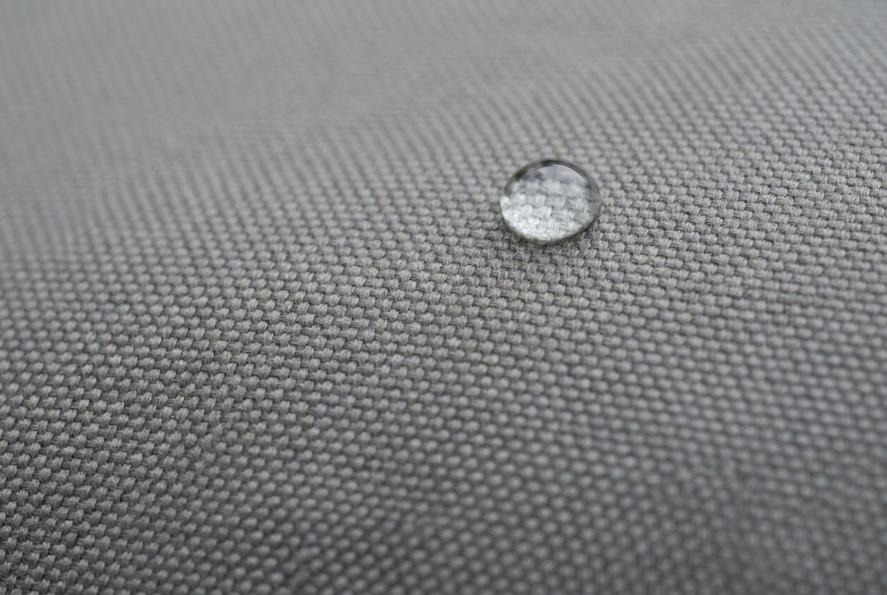 Close-up van waterdichte PU-gecoate polyesterstof met een waterdruppel